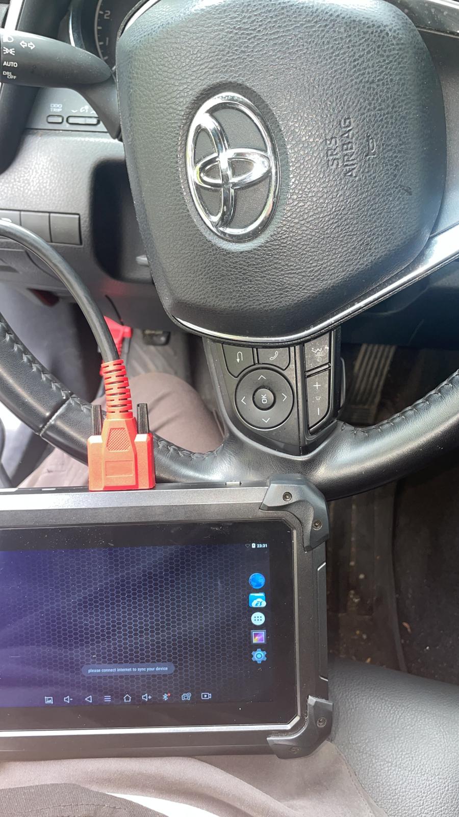 Diagnostic tablet plugged into a Toyota to program a new key